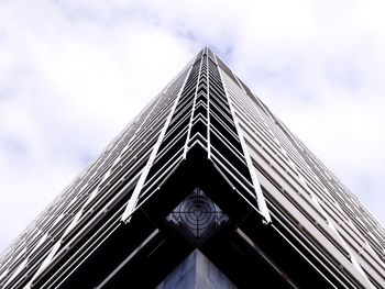 Low angle view of modern building against cloudy sky