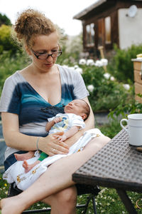 Woman with son sitting by coffee cup on table