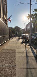 Cars on road in city against sky