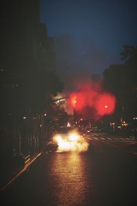 Cars on illuminated street at night