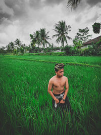 Full length of shirtless man on field