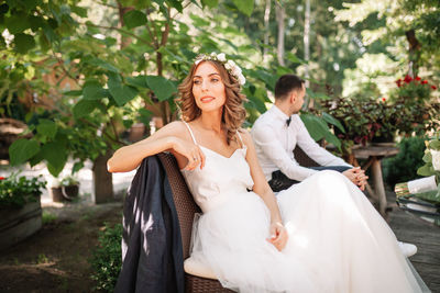 Bride and bridegroom sitting at park