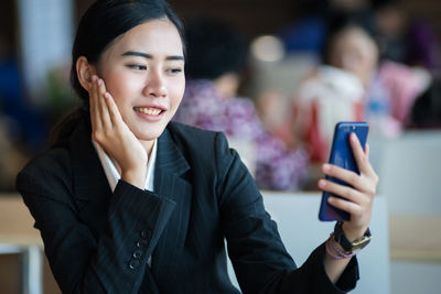 Smiling young woman using mobile phone
