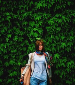 Portrait of woman standing against plants