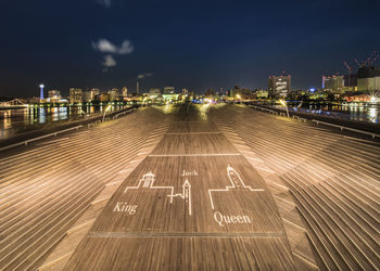 High angle view of illuminated street amidst buildings at night