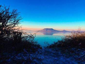 Scenic view of lake against sky at sunset