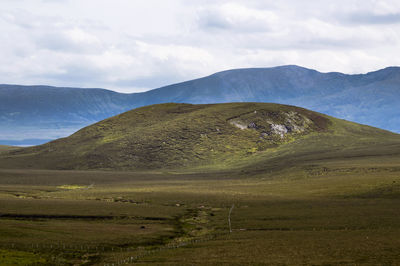 Scenic view of mountains against cloudy sky