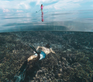 Young couple have a fun in ocean, underwater view