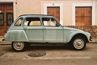 Vintage car parked on street against building