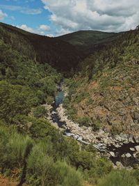 Scenic view of river amidst mountains against sky