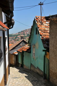 Alley amidst buildings in town against sky