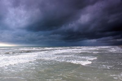 Scenic view of sea against storm clouds