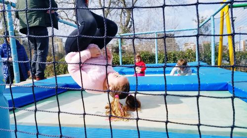 Girl backflipping on trampoline in public park