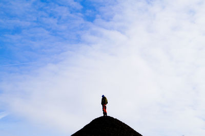 Low angle view of man on top of mountain