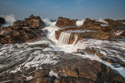 Scenic view of waterfall against sky during winter