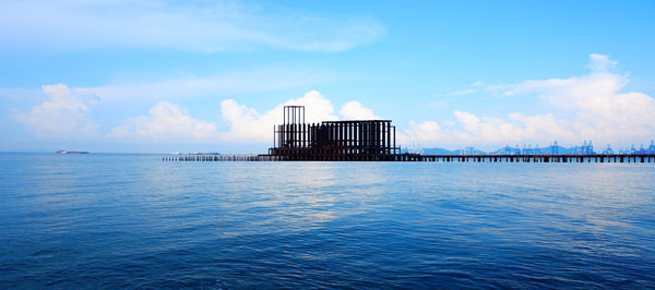 View of pier on sea against cloudy sky