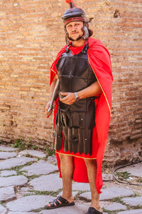 Portrait of man standing against brick wall