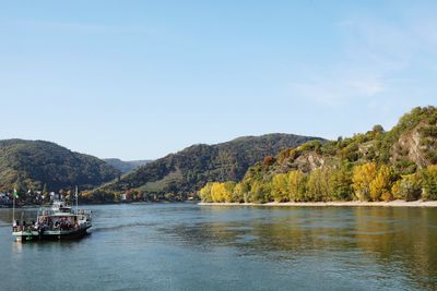 Scenic view of river and mountains against clear sky