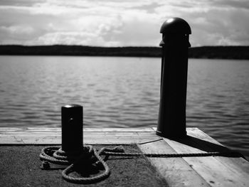 Close-up of wooden post on pier over sea against sky