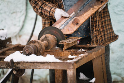 Worker grinding metal on machine