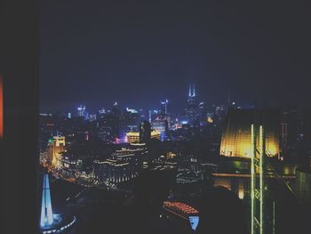 Illuminated cityscape against sky at night