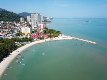 High angle view of buildings by sea against sky