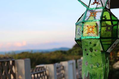 Close-up of sign on wooden post against sky