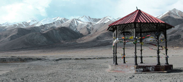 Lifeguard hut on snowcapped mountain against sky