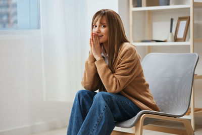 Young woman sitting on sofa at home