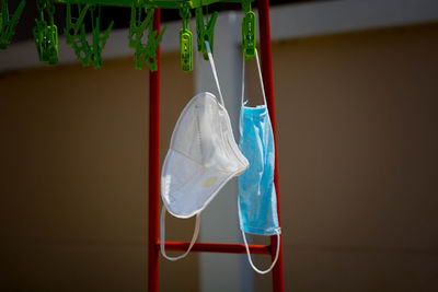 Close-up of clothes hanging on rope against wall at home