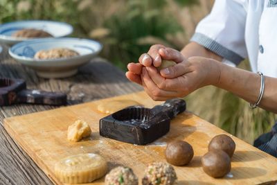 Midsection of woman preparing food on cutting board