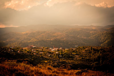 Aerial view of townscape by mountains against sky