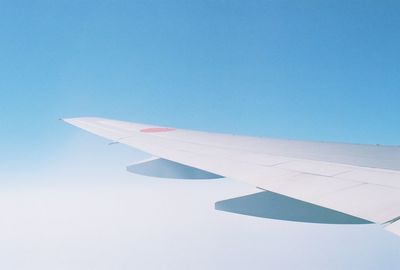 Airplane wing against clear blue sky