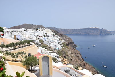 High angle view of townscape by sea against clear sky