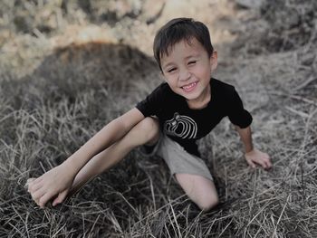 Portrait of boy sitting on field