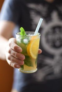 Cropped image of woman holding glass of glass of ice tea