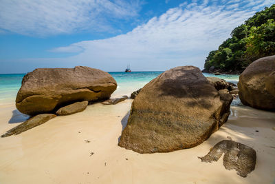 Close-up of rocks on beach against sky