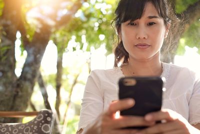 Portrait of boy using mobile phone outdoors