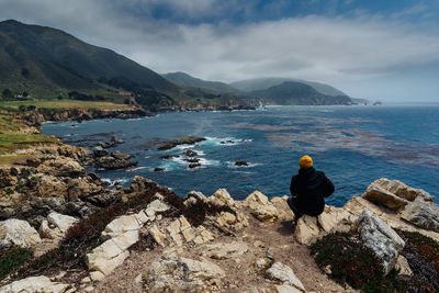 Rear view of people looking at sea against sky