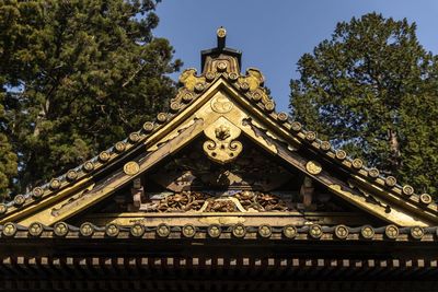 Low angle view of japanese ornate roof on temple against sky