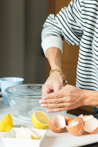 Woman greasing the baking dish while cooking apple pie in the modern kitchen