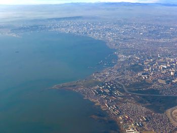 Aerial view of sea and cityscape against sky