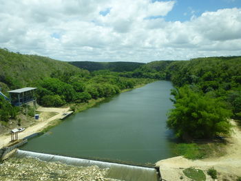 Scenic view of river amidst trees against sky