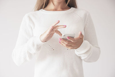 Midsection of woman holding umbrella against white background