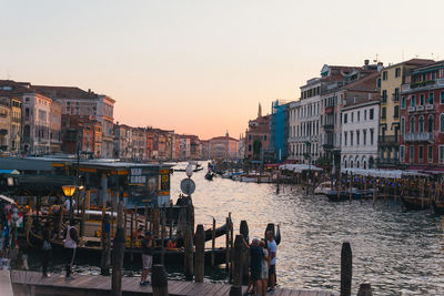 Buildings in city against clear sky during sunset