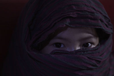Portrait of girl face covered with scarf