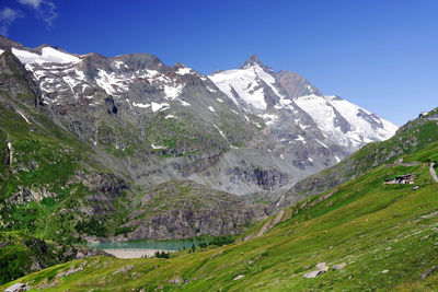 Scenic view of snowcapped mountains against blue sky