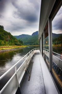 Scenic view of river by mountains against sky