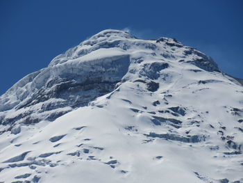 Scenic view of snow covered mountains against clear blue sky