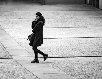 Woman standing on footpath